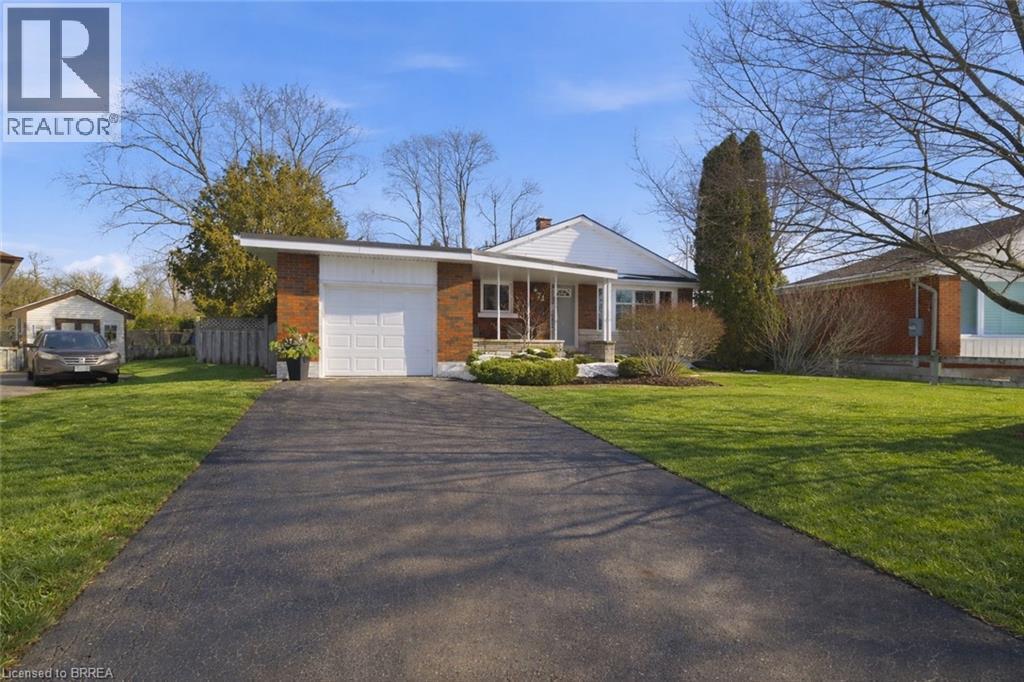 View of front of house with asphalt driveway, a garage, covered porch, a chimney, and brick siding - 71 Pinecrest Drive, Kitchener, ON - Outdoor