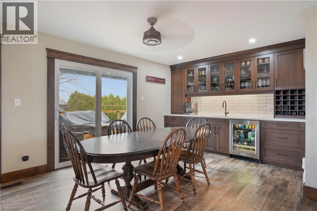 Dining room with beverage cooler, light wood-type flooring, recessed lighting, ceiling fan, and bar with sink - 23247 Beattie Line, Elgin, ON - Indoor Photo Showing Dining Room