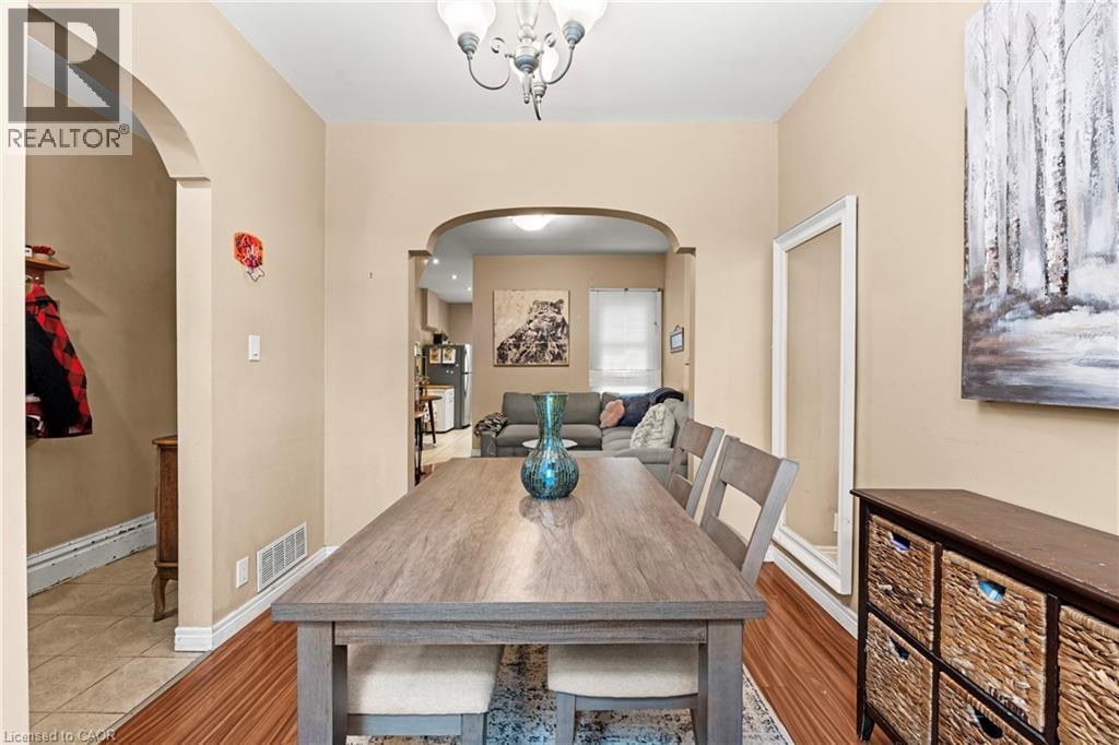 Tiled dining area with arched walkways and a chandelier - 78 Clyde Street, Hamilton, ON - Indoor Photo Showing Dining Room