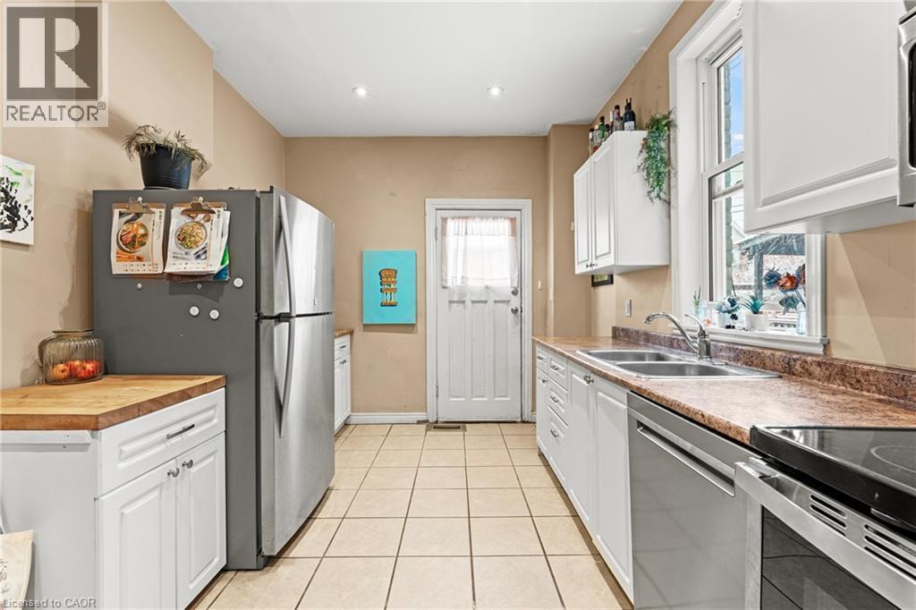 Kitchen featuring white cabinets, stainless steel appliances, light tile patterned floors, and recessed lighting - 78 Clyde Street, Hamilton, ON - Indoor Photo Showing Kitchen With Double Sink