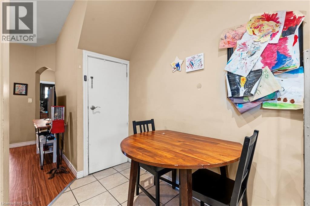 Dining area featuring arched walkways and light tile patterned floors - 78 Clyde Street, Hamilton, ON - Indoor Photo Showing Dining Room