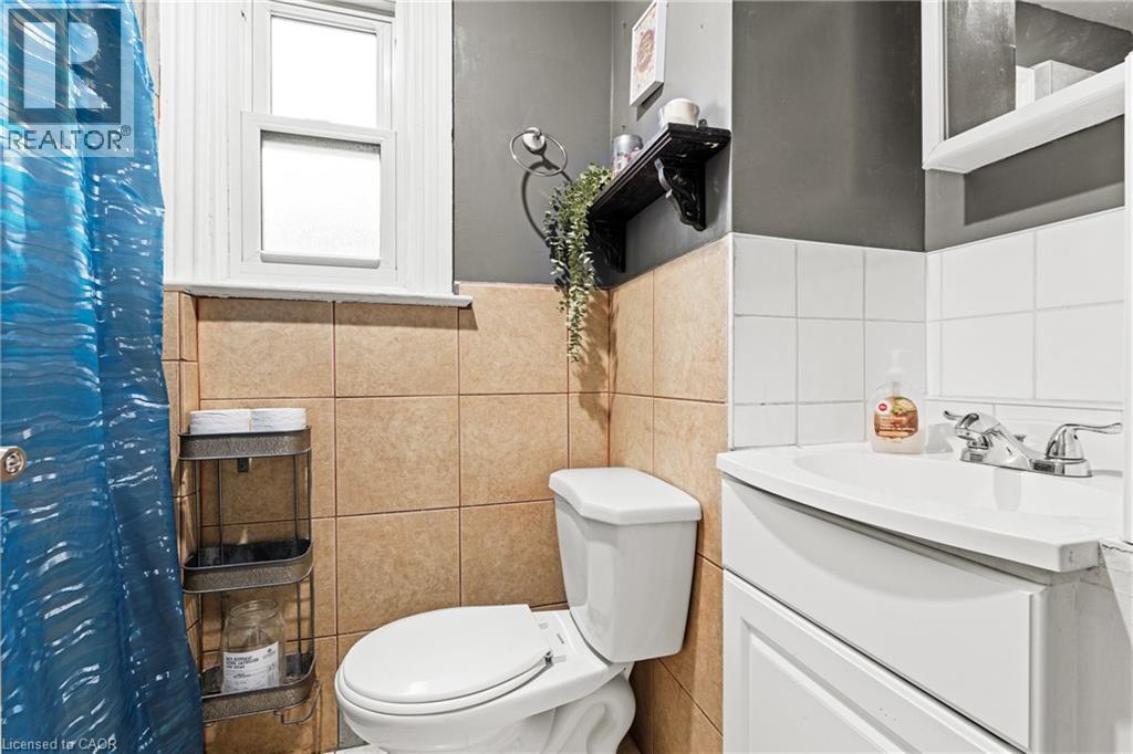 Bathroom featuring vanity, a shower with shower curtain, and tile walls - 78 Clyde Street, Hamilton, ON - Indoor Photo Showing Bathroom