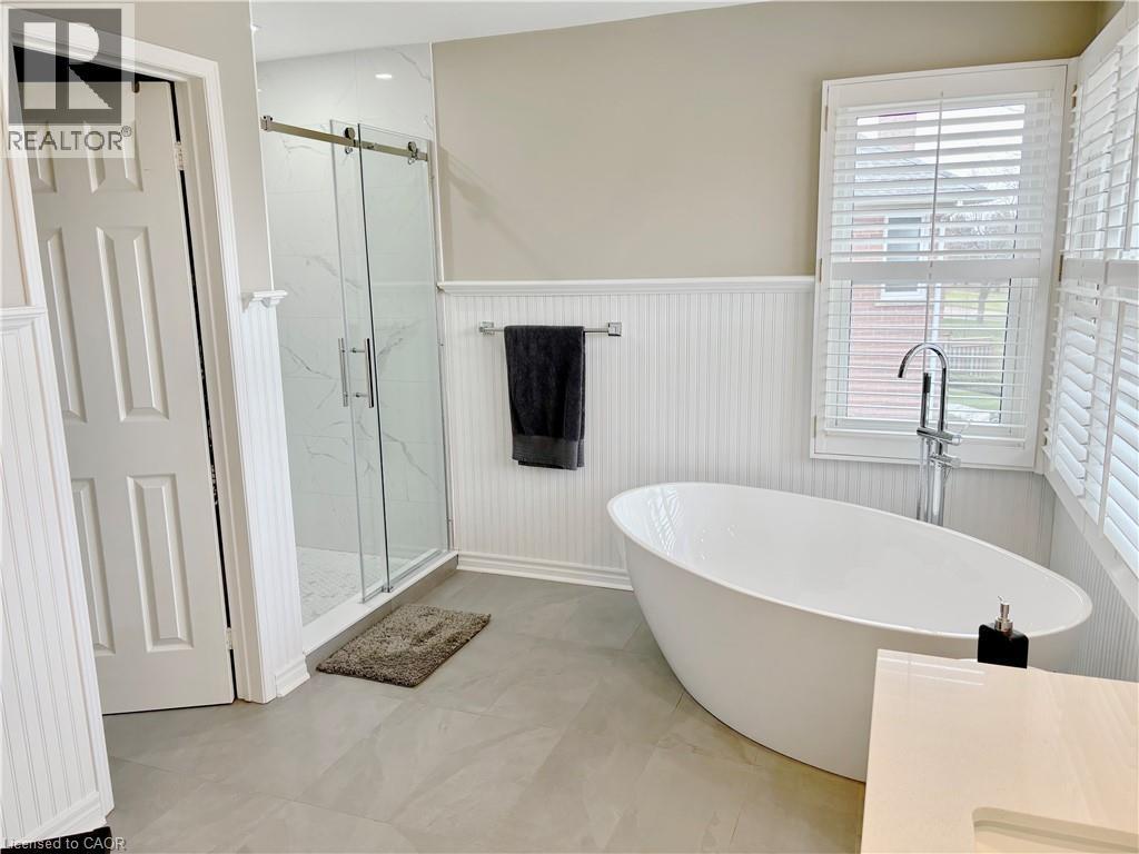Bathroom featuring a wainscoted wall, a marble finish shower, and a freestanding tub - 2056 Hadfield Court, Burlington, ON - Indoor Photo Showing Bathroom