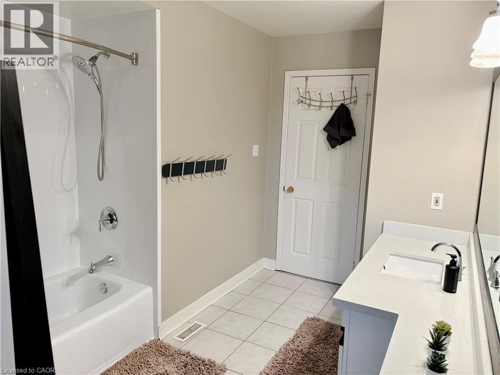 Bathroom with vanity, shower / washtub combination, and light tile patterned floors - 2056 Hadfield Court, Burlington, ON - Indoor Photo Showing Bathroom