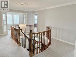 Corridor featuring a chandelier, an upstairs landing, carpet floors, and ornamental molding -