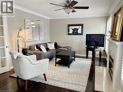 Living area with ornamental molding, hardwood / wood-style floors, ceiling fan, a textured ceiling, and a fireplace -