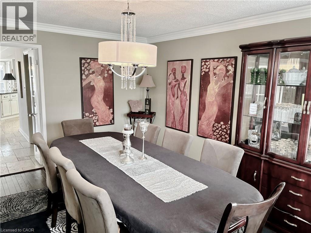 Dining room featuring a textured ceiling, crown molding, and wood finished floors - 2056 Hadfield Court, Burlington, ON - Indoor Photo Showing Dining Room