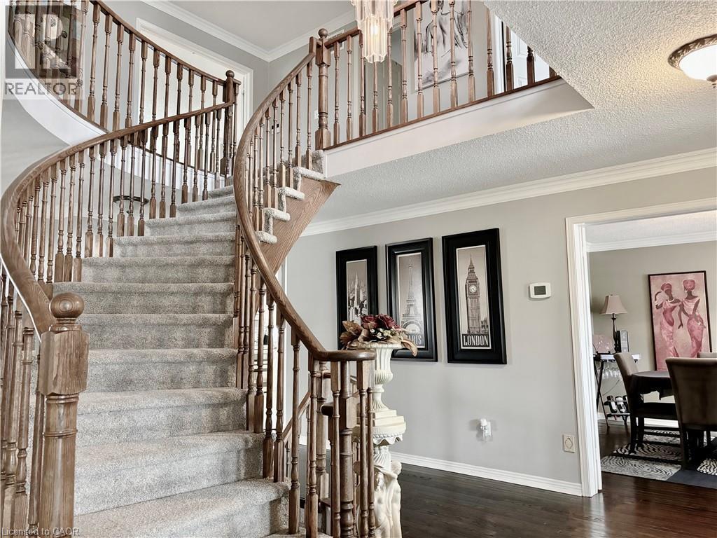 Stairs with ornamental molding, wood finished floors, and a textured ceiling - 2056 Hadfield Court, Burlington, ON - Indoor Photo Showing Other Room