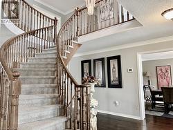 Stairs with ornamental molding, wood finished floors, and a textured ceiling -