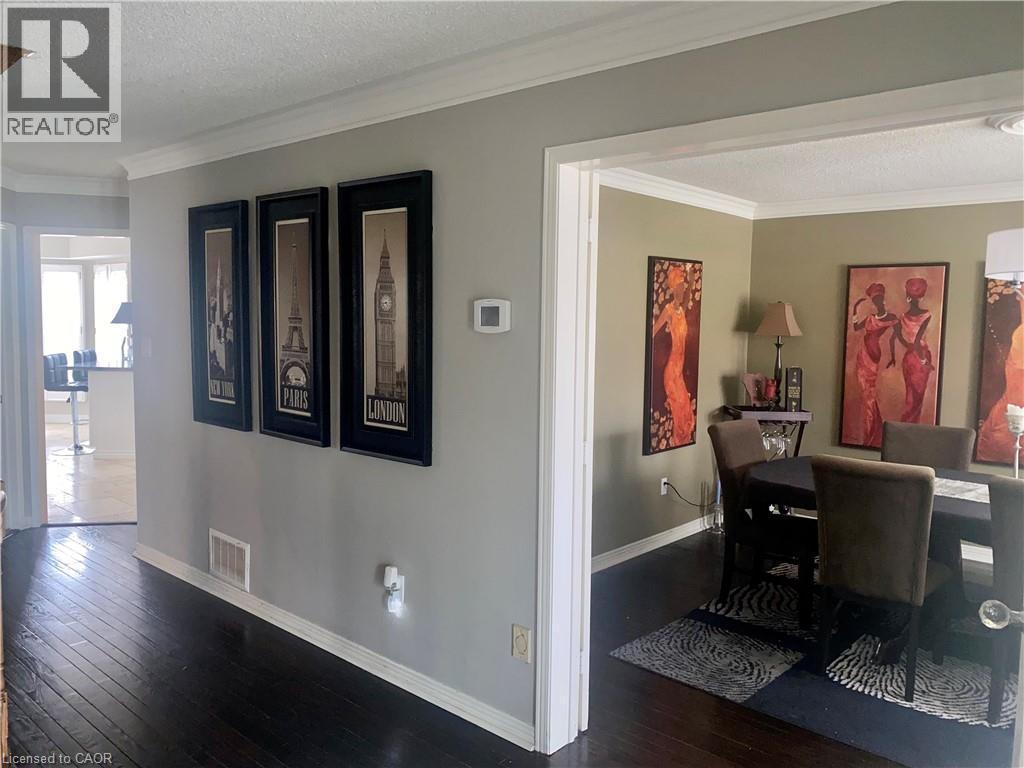 Dining space with a textured ceiling, crown molding, and dark wood-style flooring - 2056 Hadfield Court, Burlington, ON - Indoor