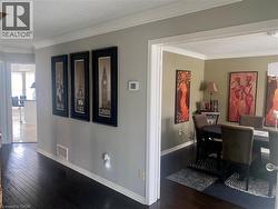 Dining space with a textured ceiling, crown molding, and dark wood-style flooring -