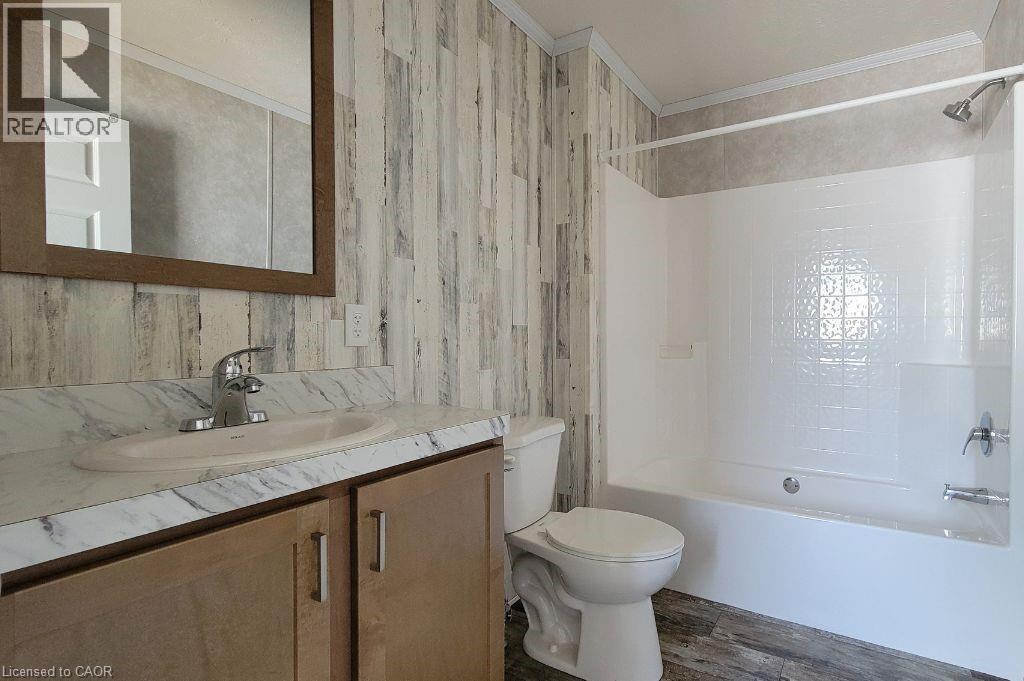 Full bathroom featuring toilet, ornamental molding, vanity, shower / bath combination, and wood finished floors - 77 Park Lane, Flamborough, ON - Indoor Photo Showing Bathroom