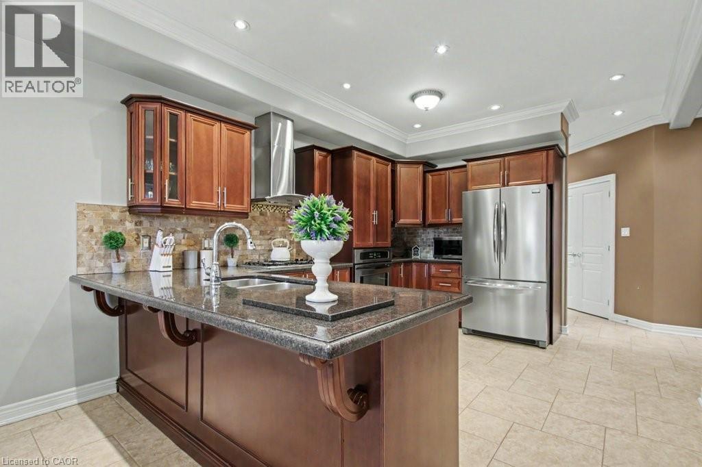 Kitchen with a peninsula, stainless steel appliances, dark stone countertops, a breakfast bar, and glass insert cabinets - 284 Normanhurst Avenue, Hamilton, ON - Indoor Photo Showing Kitchen