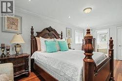 Bedroom with crown molding, wood finished floors, and recessed lighting -