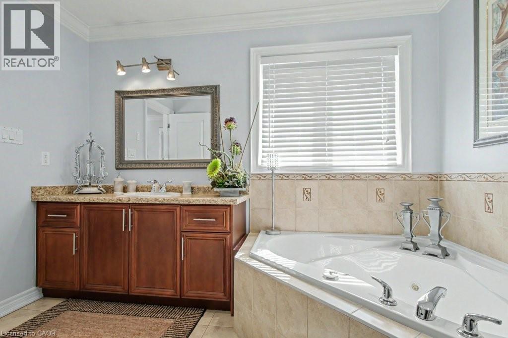 Bathroom with vanity, a whirlpool tub, ornamental molding, and light tile patterned floors - 284 Normanhurst Avenue, Hamilton, ON - Indoor Photo Showing Bathroom