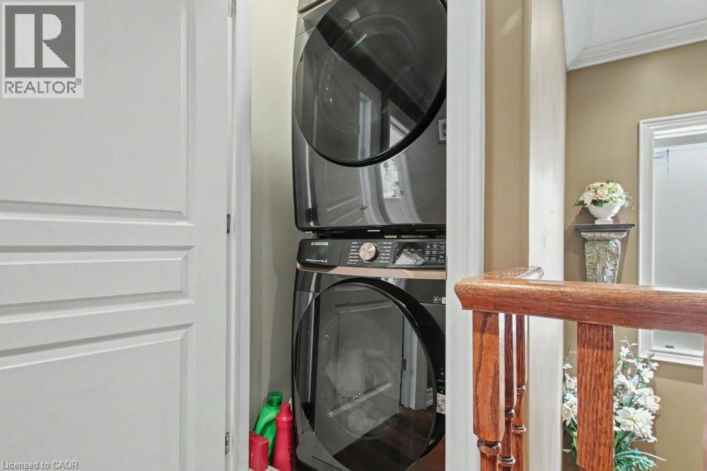 Laundry area with stacked washer / drying machine and a wall mounted mini split - 284 Normanhurst Avenue, Hamilton, ON - Indoor Photo Showing Laundry Room
