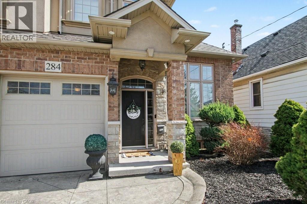 Entrance to property with stone siding, a garage, and roof with shingles - 284 Normanhurst Avenue, Hamilton, ON - Outdoor