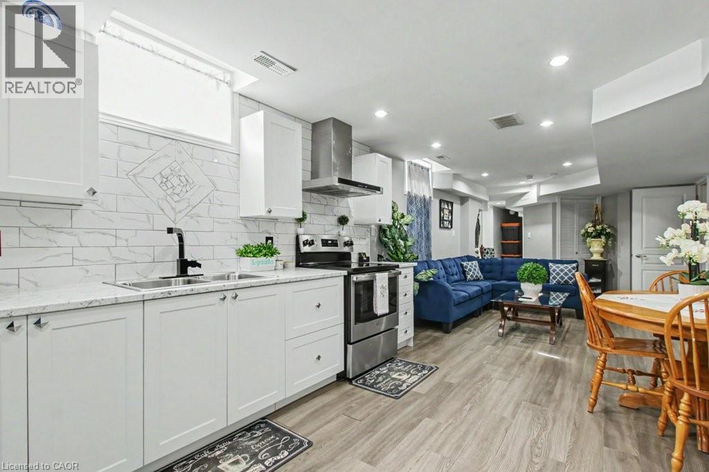 Kitchen with electric stove, open floor plan, light wood finished floors, white cabinets, and recessed lighting - 284 Normanhurst Avenue, Hamilton, ON - Indoor Photo Showing Kitchen With Double Sink With Upgraded Kitchen
