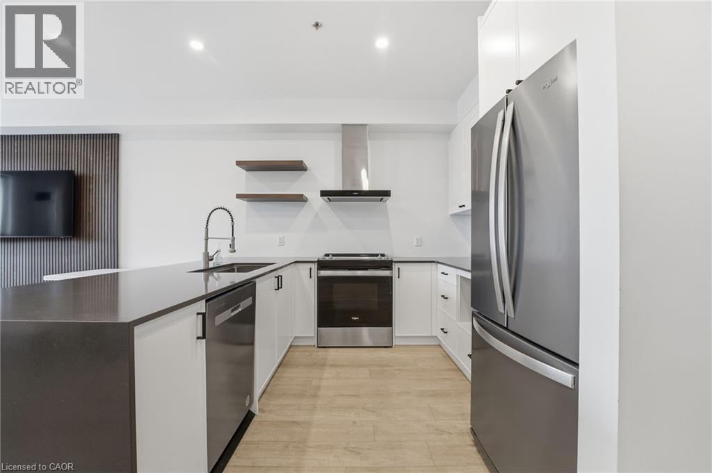 Kitchen featuring a peninsula, stainless steel appliances, white cabinets, open shelves, and recessed lighting - 120 Springvalley Crescent Unit# 203, Hamilton, ON - Indoor Photo Showing Kitchen With Stainless Steel Kitchen With Upgraded Kitchen