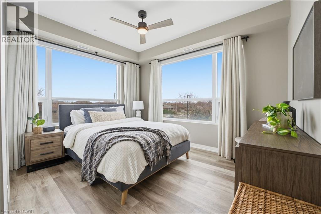 Bedroom featuring light wood-type flooring and a ceiling fan - 120 Springvalley Crescent Unit# 203, Hamilton, ON - Indoor Photo Showing Bedroom