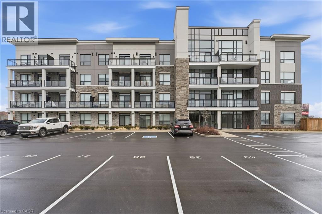 View of apartment building / complex featuring uncovered parking - 120 Springvalley Crescent Unit# 203, Hamilton, ON - Outdoor With Balcony With Facade