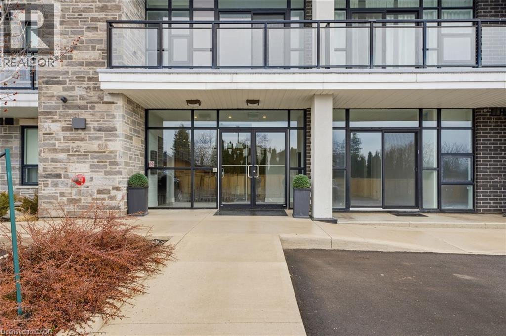 Property entrance featuring a patio and stone siding - 120 Springvalley Crescent Unit# 203, Hamilton, ON - Outdoor With Balcony