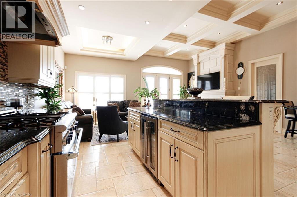 Kitchen with open floor plan, dark stone counters, stainless steel range, extractor fan, and stone tile flooring - 205 Paige Place, Kitchener, ON - Indoor Photo Showing Kitchen With Upgraded Kitchen