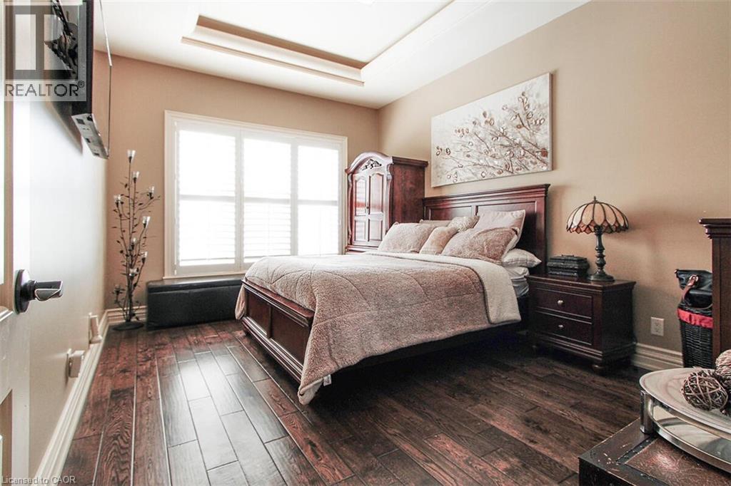 Bedroom featuring dark wood finished floors and a tray ceiling - 205 Paige Place, Kitchener, ON - Indoor Photo Showing Bedroom