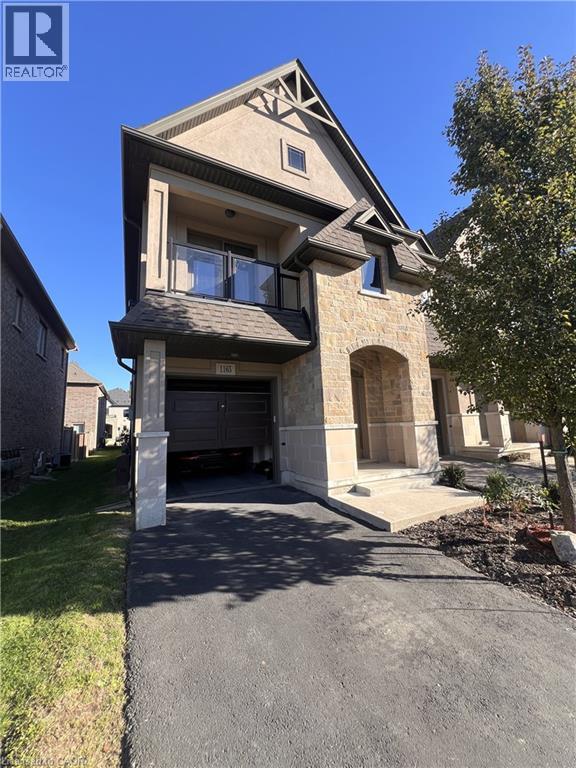 View of front facade featuring a balcony, stone siding, driveway, and an attached garage - 1165 West 5Th Street, Hamilton, ON - Outdoor