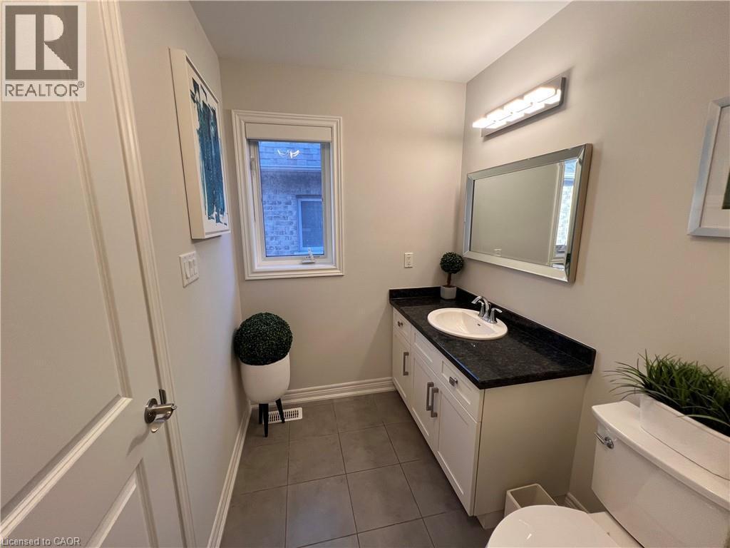 Half bathroom featuring vanity and dark tile patterned floors - 1165 West 5Th Street, Hamilton, ON - Indoor Photo Showing Bathroom
