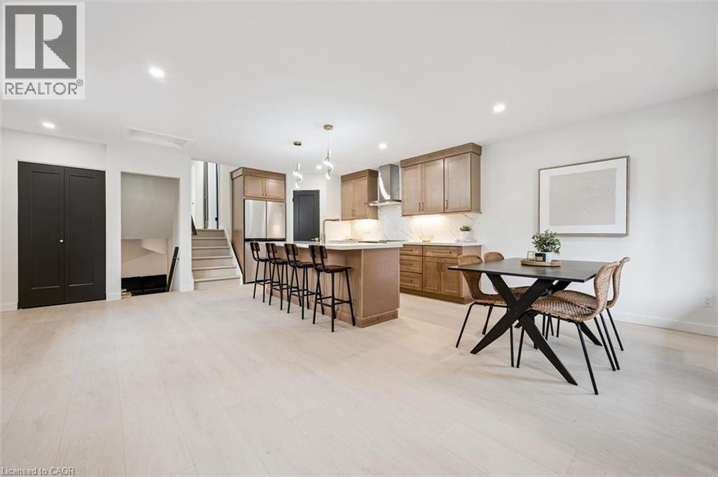 Kitchen with a kitchen bar, a center island, light countertops, decorative backsplash, and decorative light fixtures - 459 Drummerhill Crescent, Waterloo, ON - Indoor