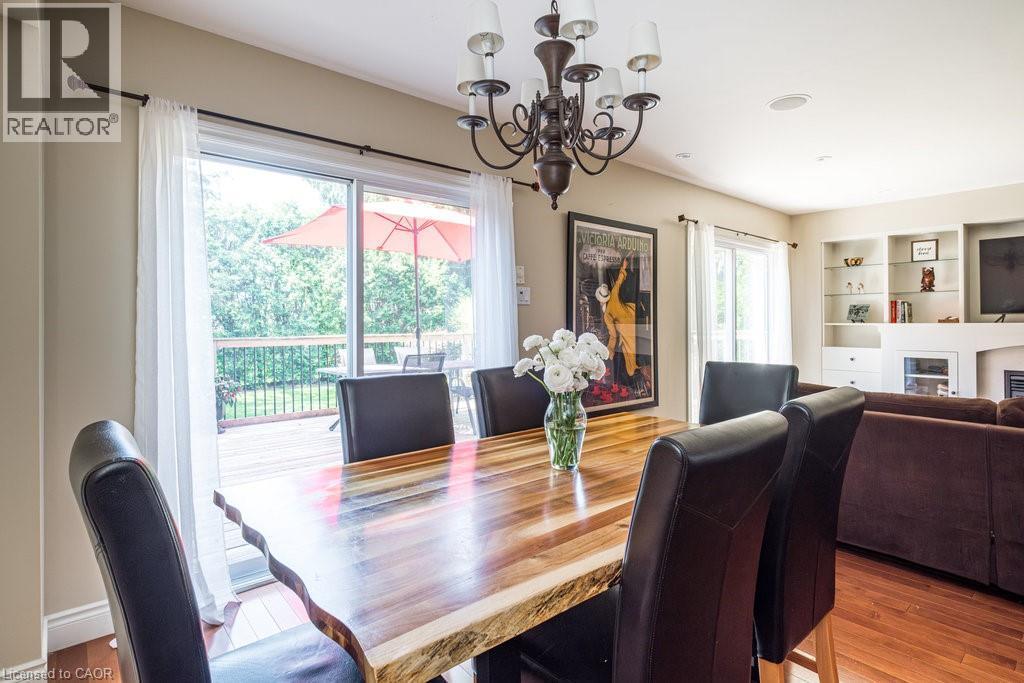 Dining area with hanging lights, a glass covered fireplace, and wood finished floors - 330 Strathcona Drive, Burlington, ON - Indoor Photo Showing Dining Room