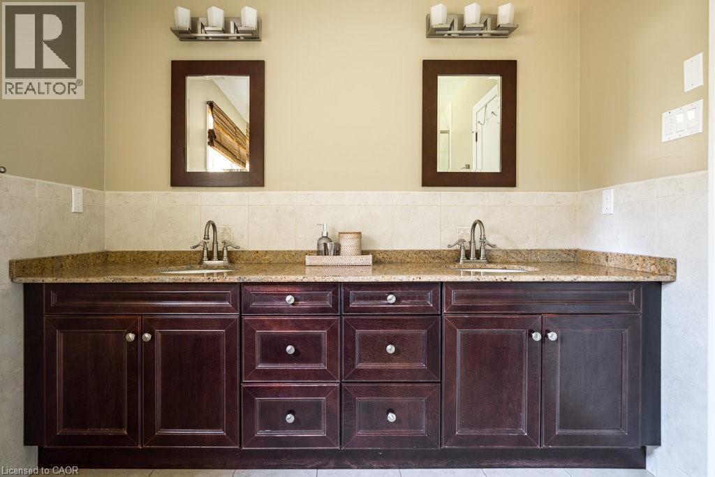 Bathroom with double vanity, tile walls, wainscoting, and light tile patterned flooring - 330 Strathcona Drive, Burlington, ON - Indoor Photo Showing Bathroom