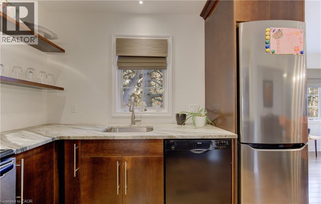 Kitchen with freestanding refrigerator, black dishwasher, light stone counters, open shelves, and wood finish cabinets - 306 Roxton Drive, Waterloo, ON - Indoor Photo Showing Kitchen