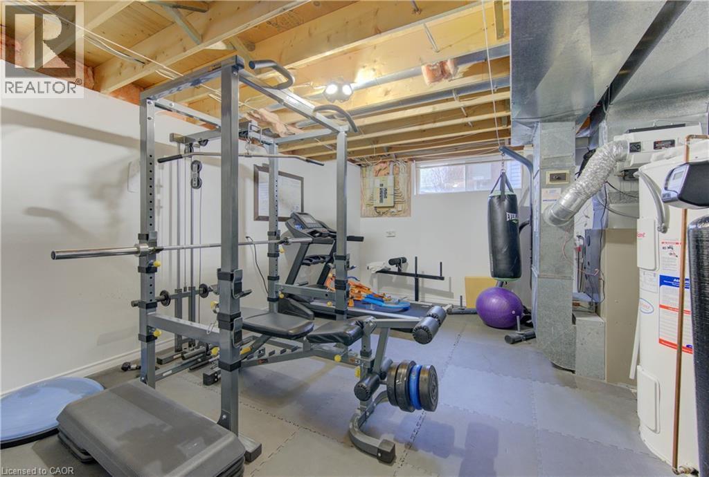 Exercise room featuring electric water heater and light rubber floors - 306 Roxton Drive, Waterloo, ON - Indoor Photo Showing Gym Room