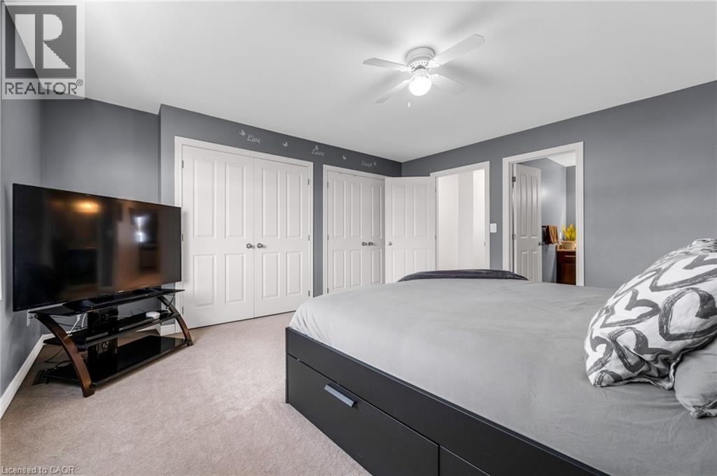 Bedroom with two closets, light colored carpet, a ceiling fan, and ensuite bath - 160 Wallace Avenue S, Welland, ON - Indoor Photo Showing Bedroom