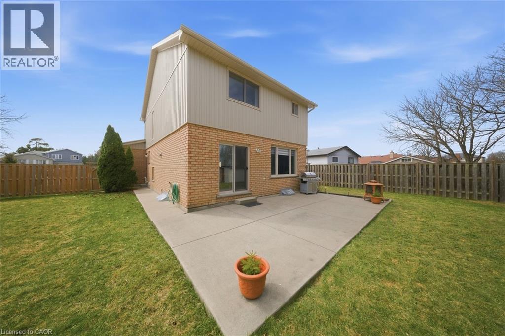 Rear view of property featuring brick siding, a patio, and a fenced backyard - 200 Morrison Drive, Caledonia, ON - Outdoor