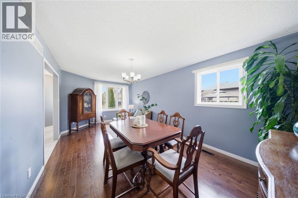 Dining space with dark wood-style flooring and suspended lighting - 200 Morrison Drive, Caledonia, ON - Indoor Photo Showing Dining Room
