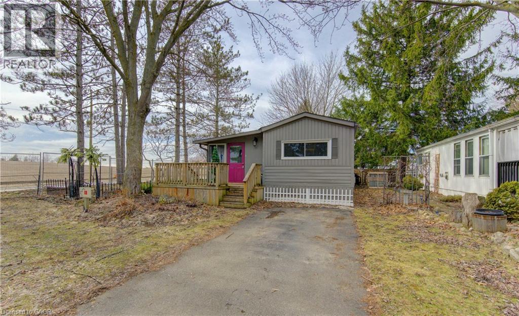 Manufactured / mobile home featuring a deck and asphalt driveway - 580 Beaver Creek Road Unit# 11, Waterloo, ON - Outdoor