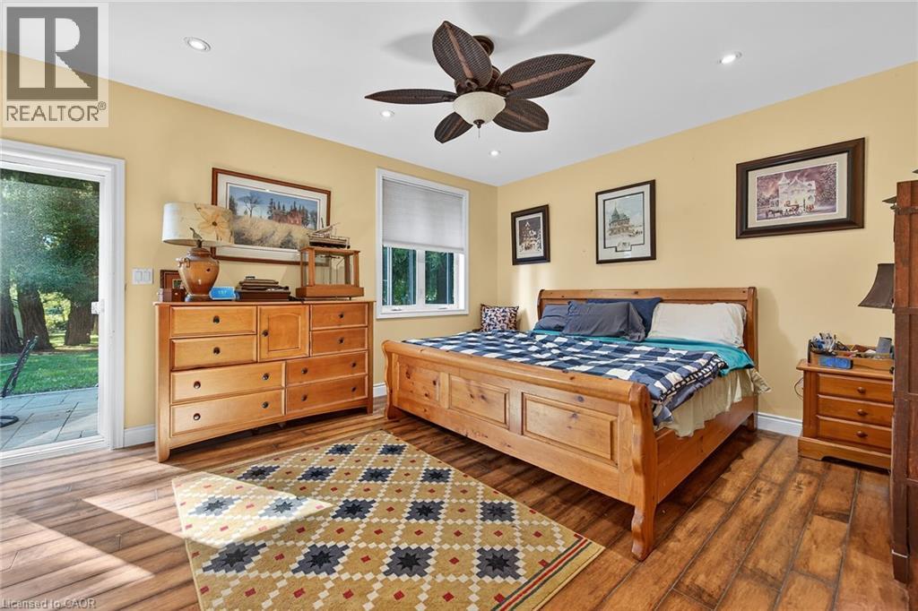 Bedroom featuring access to exterior, wood finished floors, a ceiling fan, and recessed lighting - 5590 Blind Line, Burlington, ON - Indoor Photo Showing Bedroom