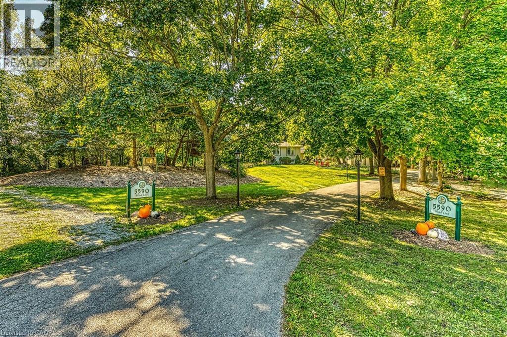 View of community featuring view of wooded area and driveway - 5590 Blind Line, Burlington, ON - Outdoor