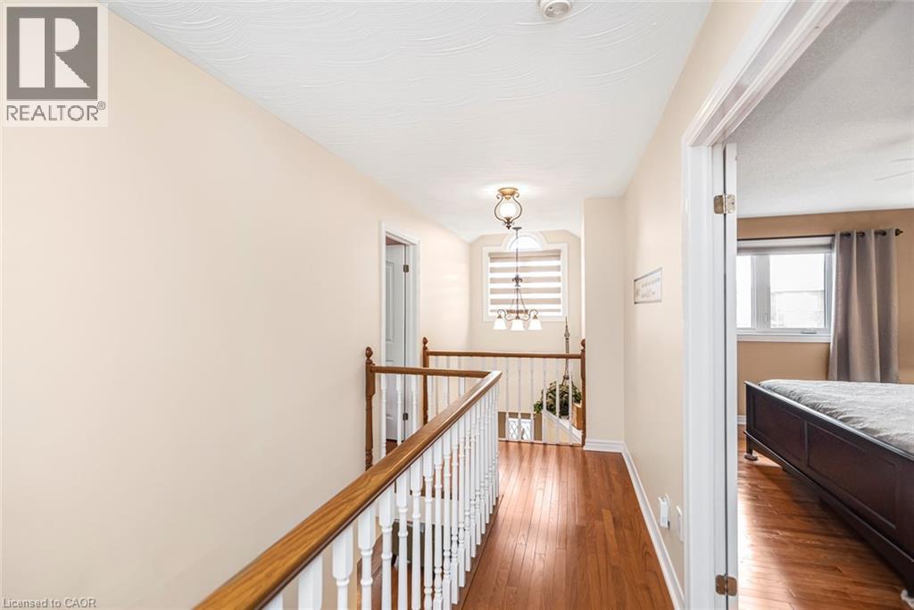 Hall featuring hardwood / wood-style floors, suspended lighting, and an upstairs landing - 40 Artistic Boulevard, Hamilton, ON - Indoor Photo Showing Other Room