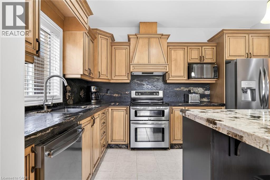 Kitchen featuring dark stone counters, stainless steel appliances, granite counters, potlights - 182 Irwin Avenue, Hamilton, ON - Indoor Photo Showing Kitchen With Double Sink