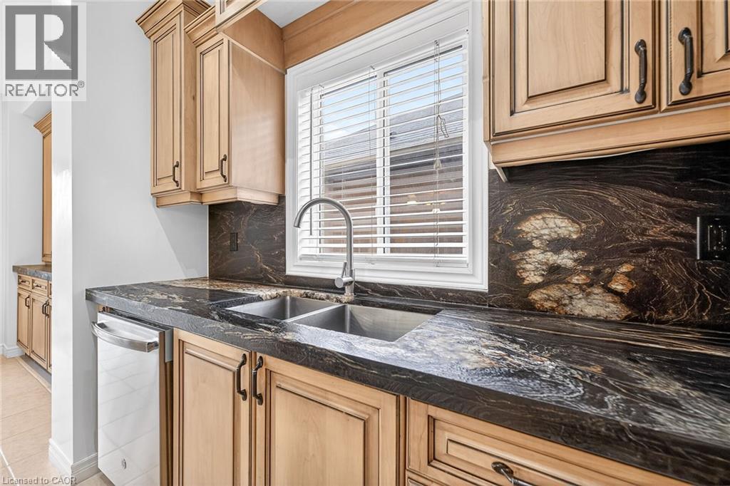 Kitchen with tasteful backsplash, dark stone counters, dishwasher, and light wood finish cabinets - 182 Irwin Avenue, Hamilton, ON - Indoor Photo Showing Kitchen With Double Sink With Upgraded Kitchen