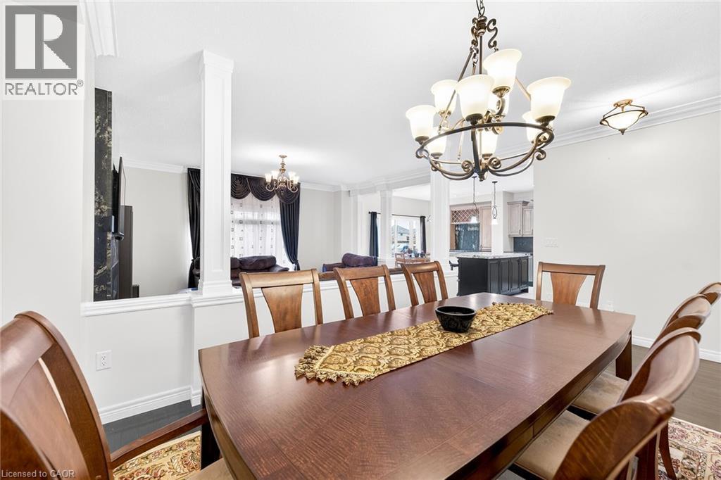 Dining room with suspended lighting, crown molding, and wood finished floors - 182 Irwin Avenue, Hamilton, ON - Indoor Photo Showing Dining Room