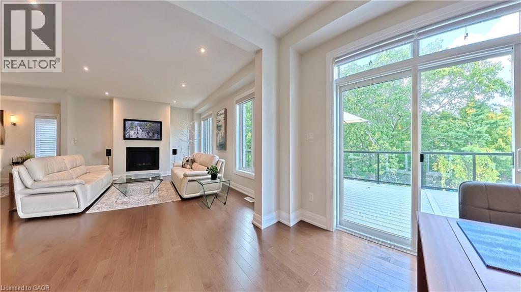 Living room featuring hardwood / wood-style flooring, a fireplace, and recessed lighting - 63 Ian Ormston Drive, Kitchener, ON - Indoor Photo Showing Living Room