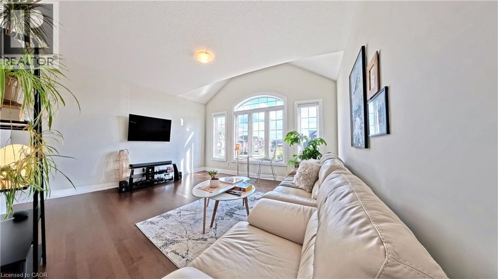 Living area featuring lofted ceiling and dark wood finished floors - 63 Ian Ormston Drive, Kitchener, ON - Indoor Photo Showing Living Room