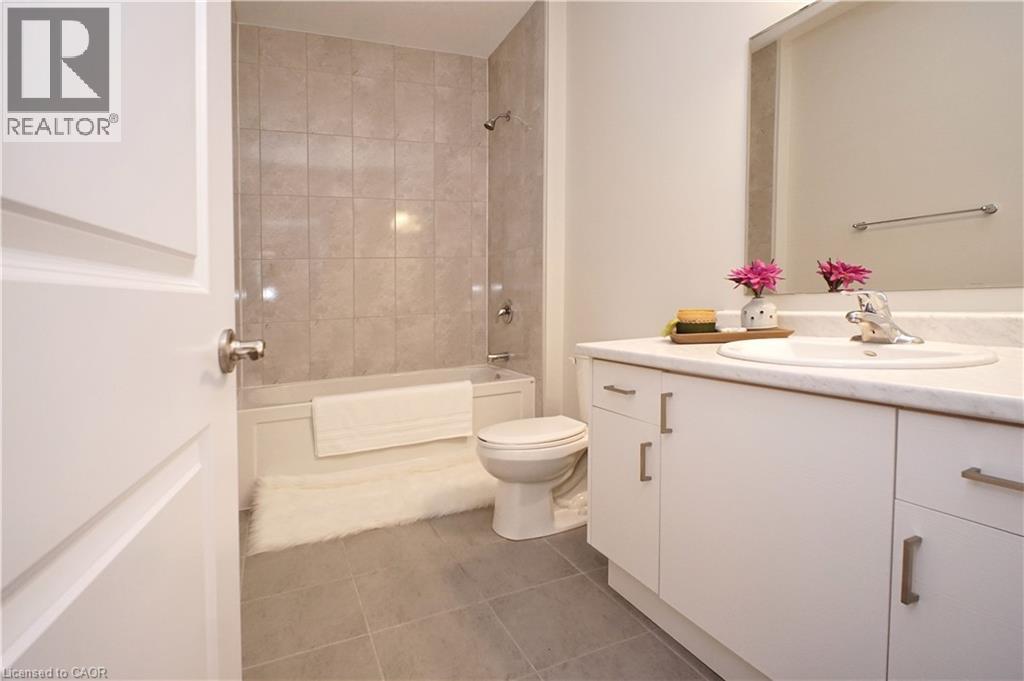 Bathroom featuring vanity, dark tile patterned floors, and shower combination - 63 Ian Ormston Drive, Kitchener, ON - Indoor Photo Showing Bathroom