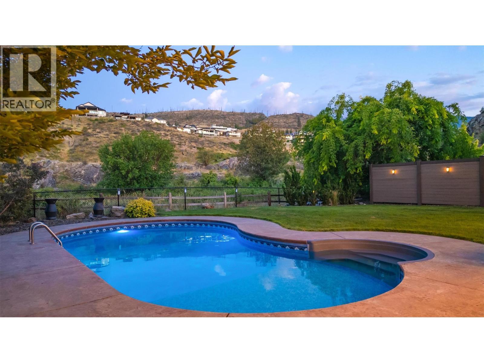 Walk from your main level right out to your amazing backyard ...watch the kids play from your kitchen! - 425 Audubon Court, Kelowna, BC - Outdoor With In Ground Pool With Backyard