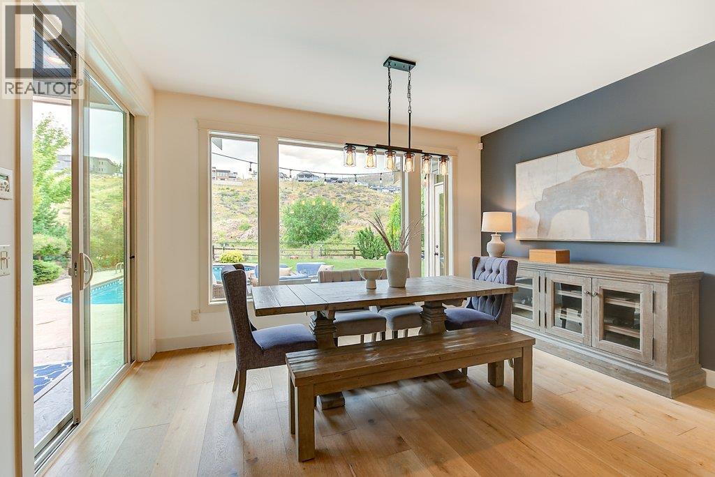 Spacious dining area opening to covered deck space. - 425 Audubon Court, Kelowna, BC - Indoor Photo Showing Dining Room With Fireplace